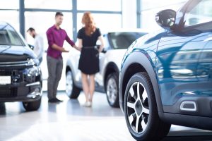 Low angle of exclusive car in a dealing salon with seller and bu